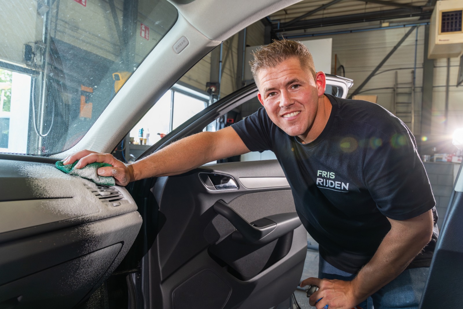 Medewerker van Fris Rijden reinigt het interieur met aandacht voor detail